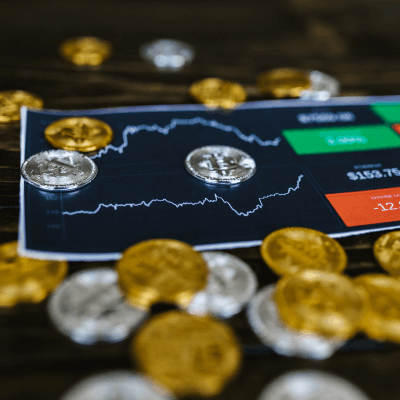 Gold and silver price charts on a tablet with financial data showing ETF decline