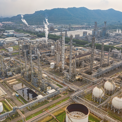 Oil dispute barrels with stock market chart overlay reflecting oil market reactions to Guyana–Venezuela tensions.